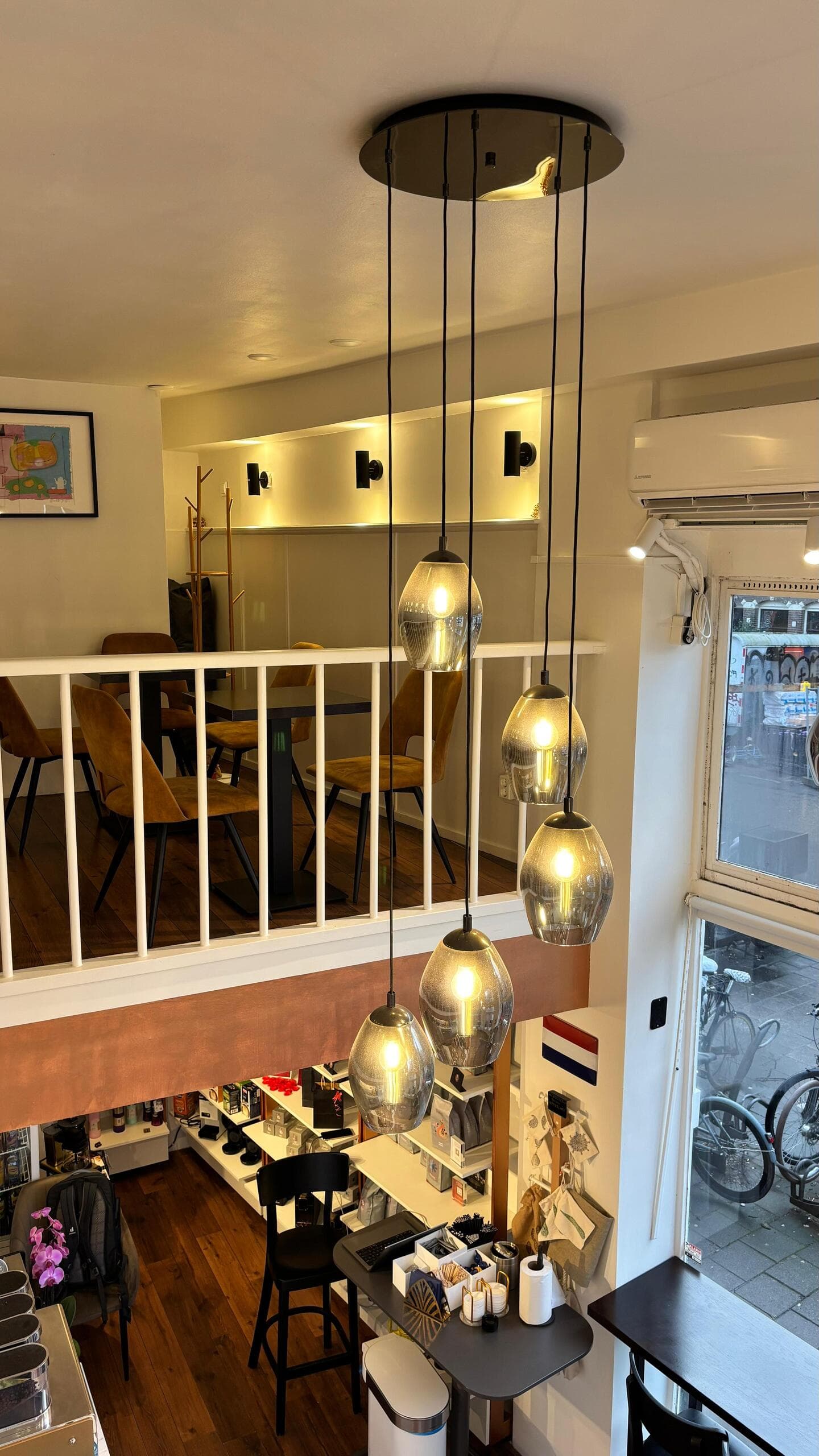 Warm pendant lights hanging over the cozy mezzanine seating area
